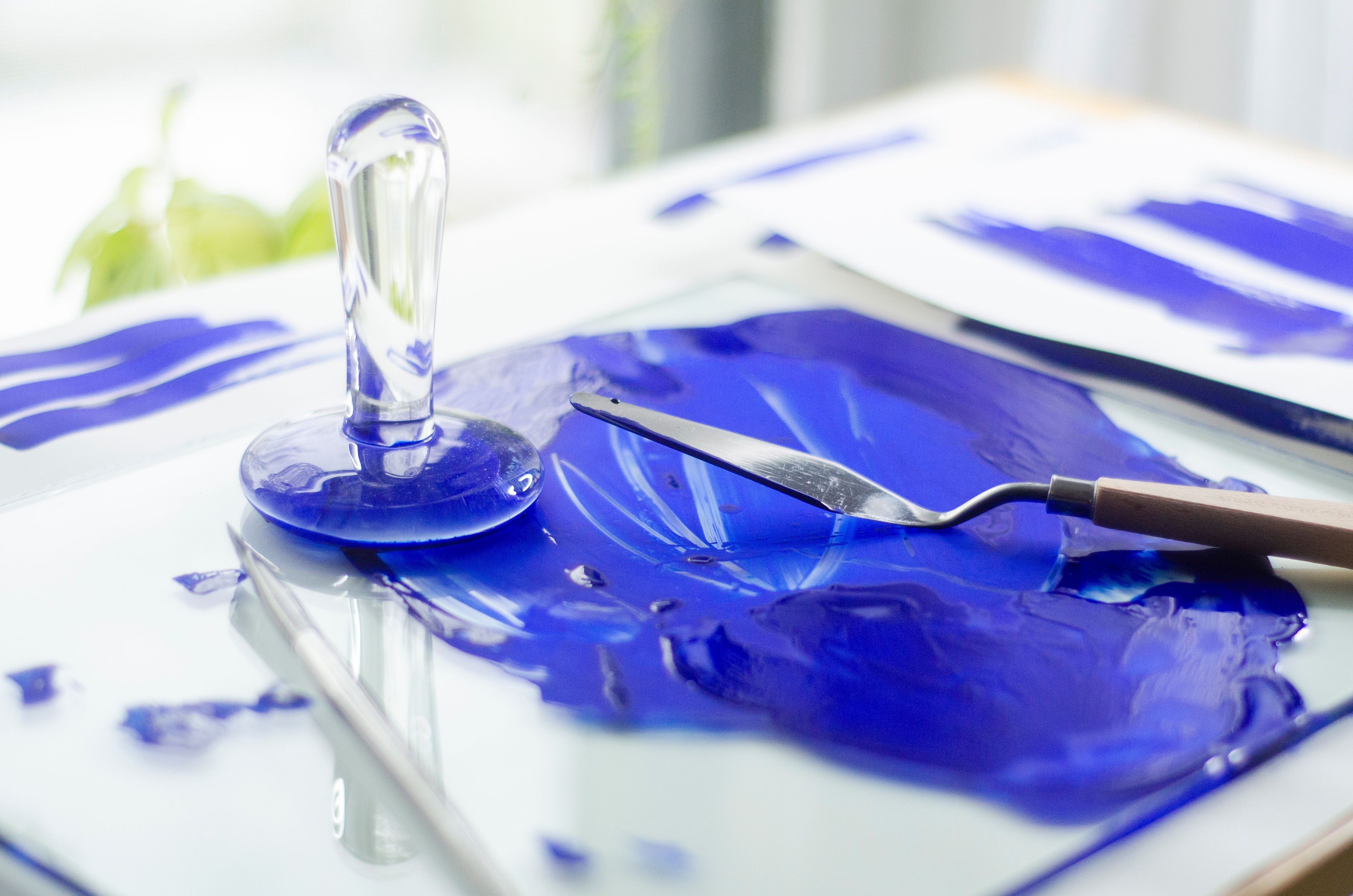 blue watercolor on pallet with muller and pallet knife