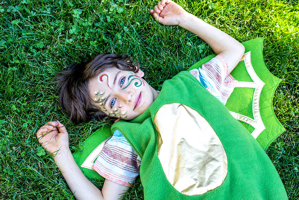 Small child with painted face and green flying lizard costume