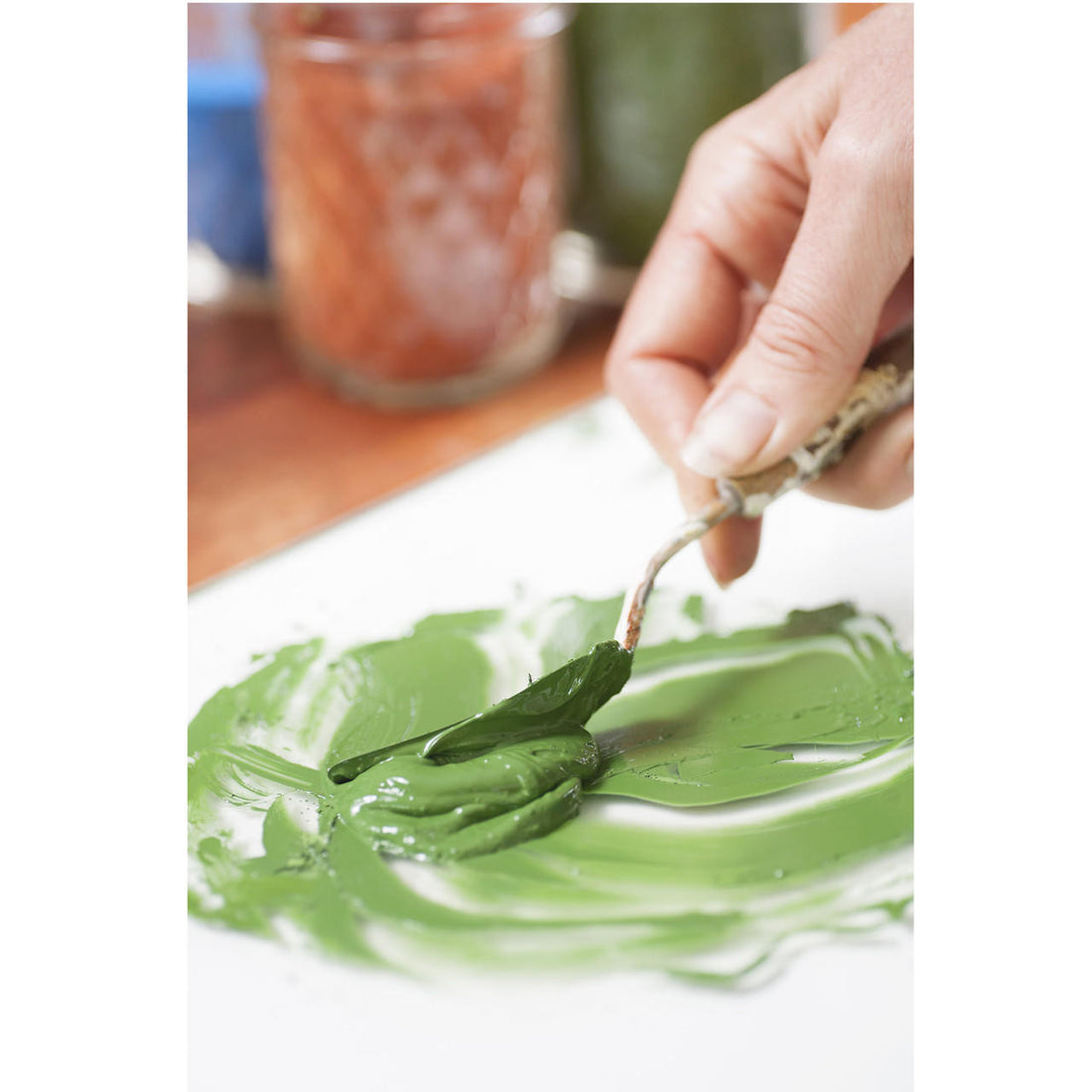 Green pigment being mixed with  a palette knife
