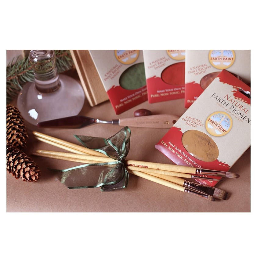 The four fine art paint brushes tied together with a ribbon bow alongside four three ounce packets of pigment, a palette knife, a glass muller and intimations of yuletide