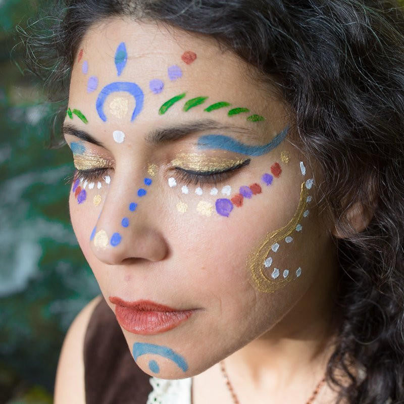 Young woman with painted face in a meditative pose