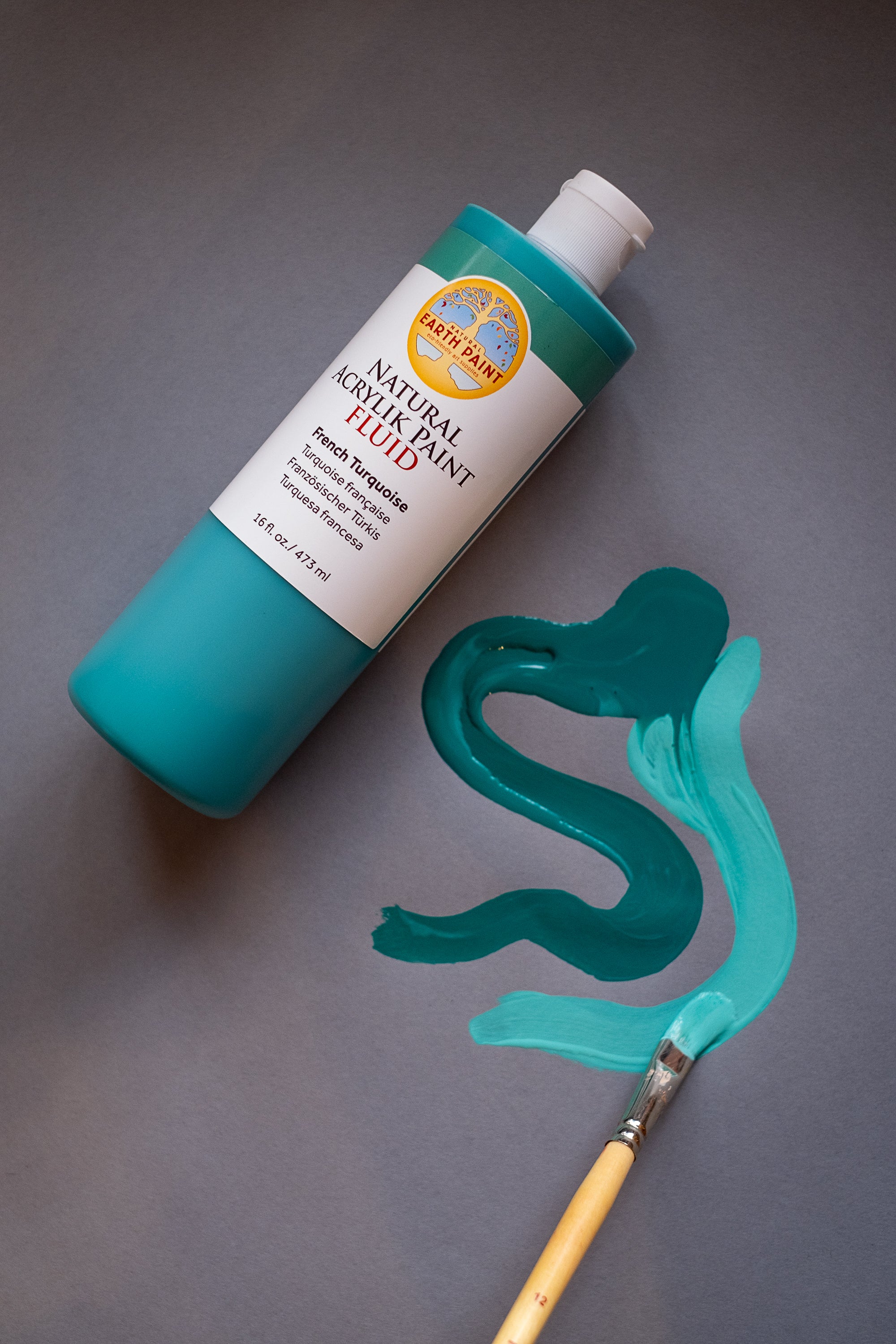 turquoise fluid acrylic paint and brush