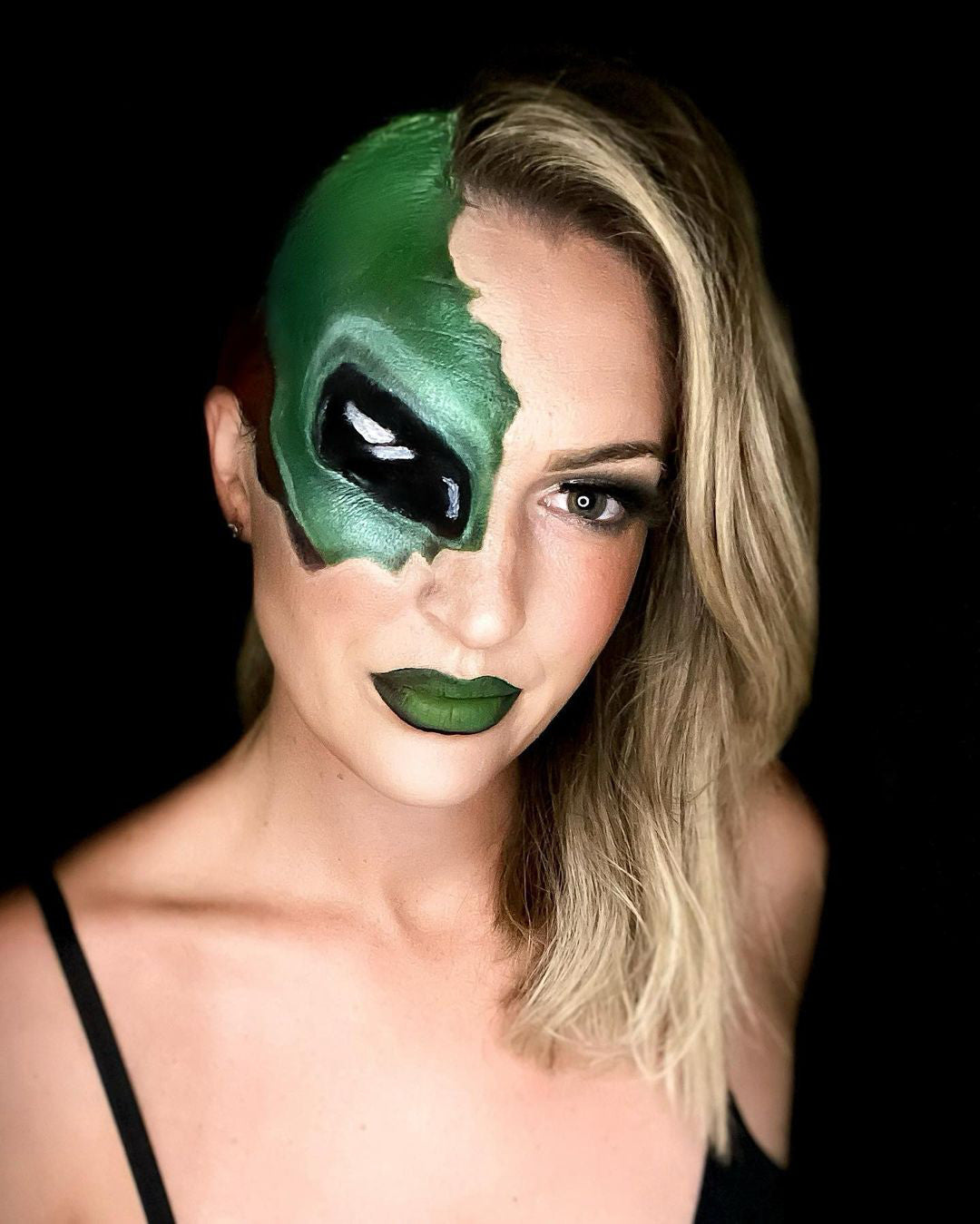 Young woman whose face has been painted to resemble an alien