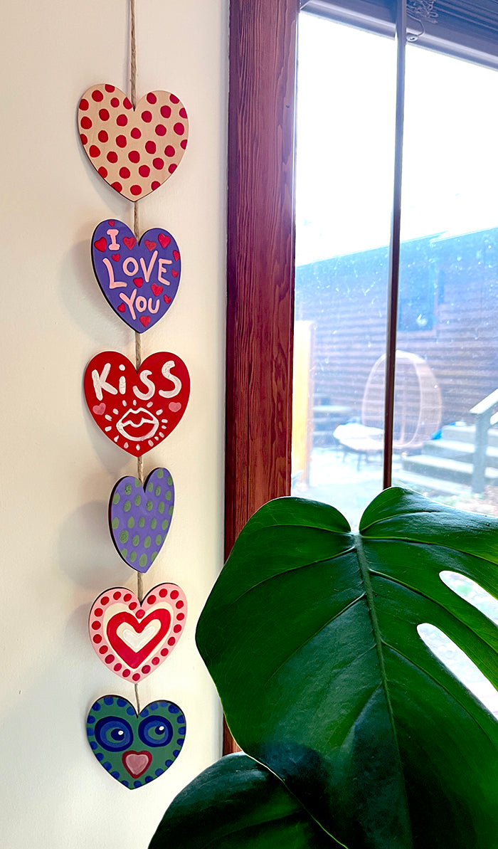 wooden hearts on cord to make a chain hanging by window