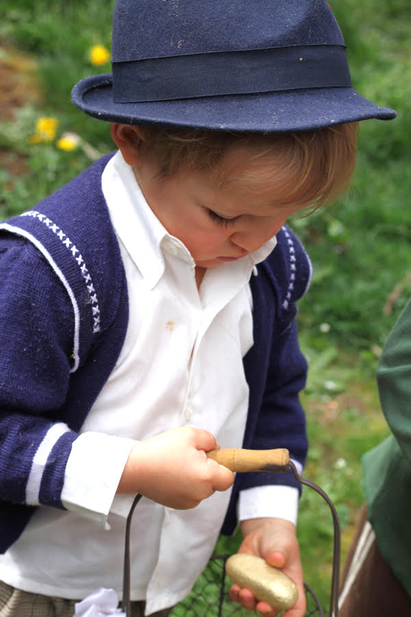 Young boy holding a gold painted rock that looks like a gold nugget