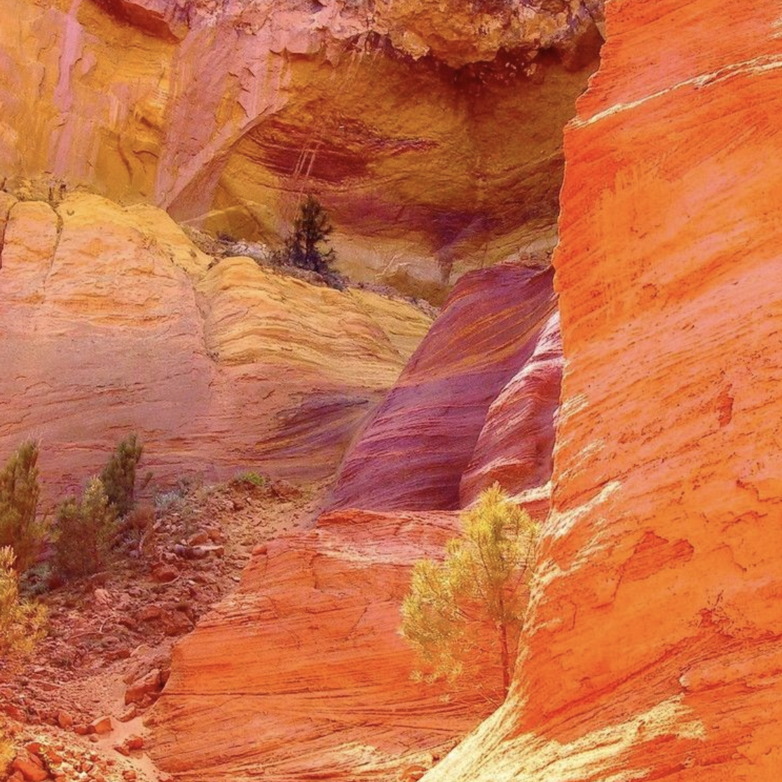 Photo of beautiful natural cliff faces displaying a range of colors varying between yellows, pinks, oranges, reds and browns