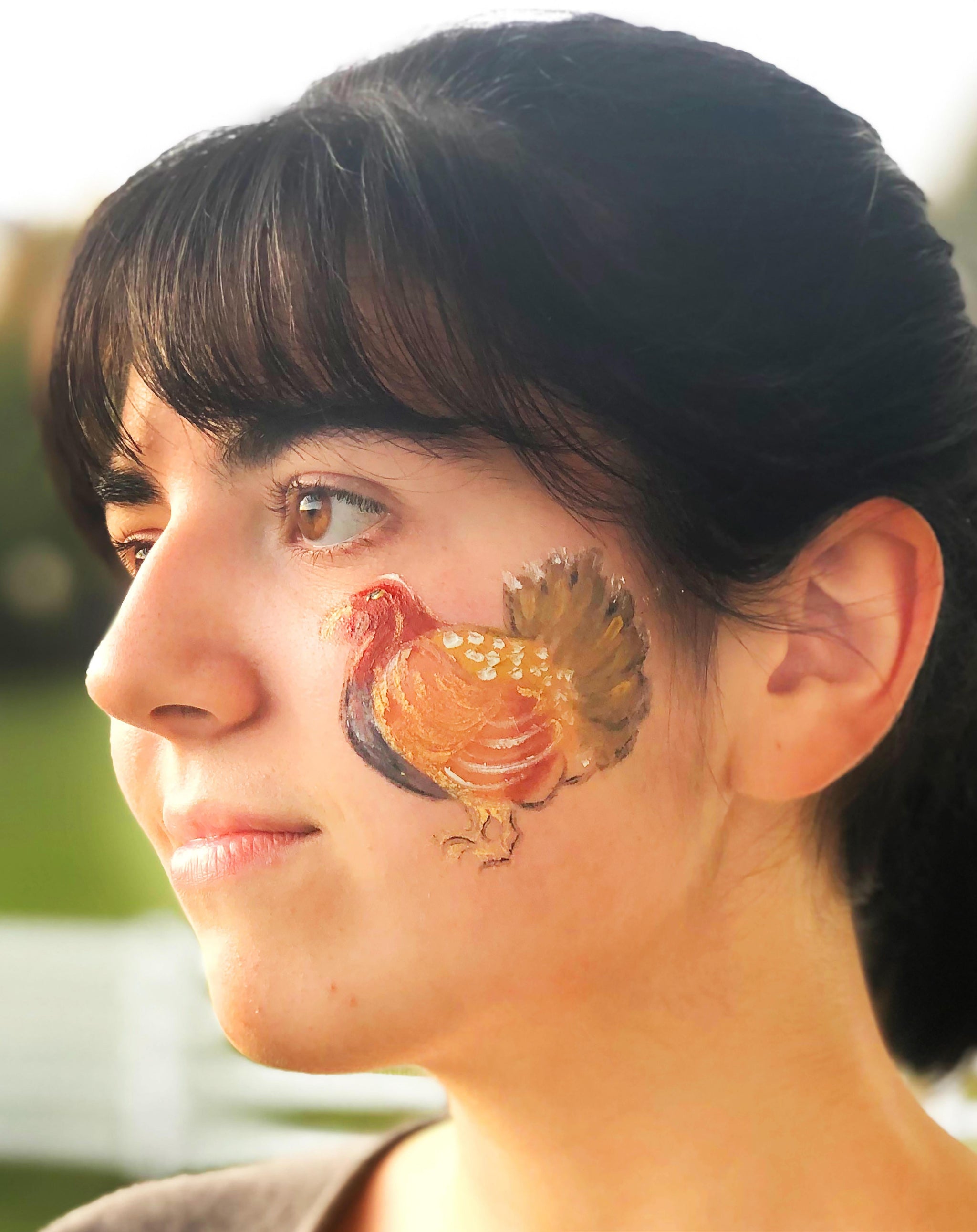 Woman's face painted with a realistic turkey on her cheek