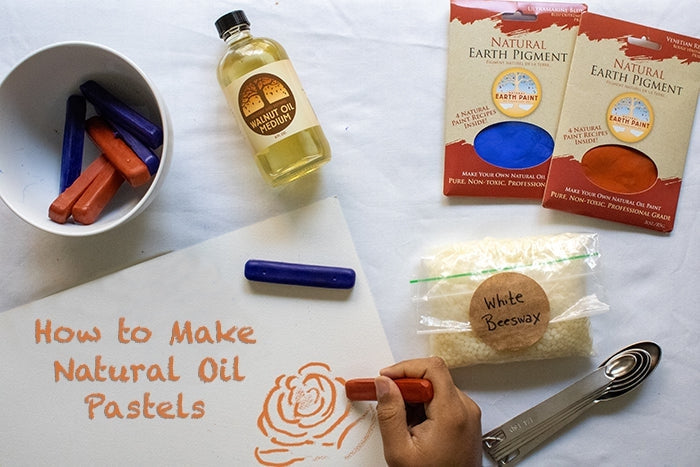 Table with a bowl of oil pastels, beeswax, glass bottle of walnut oil, metal measuring spoons, 2 packets of Earth & Mineral Pigments (red and blue)