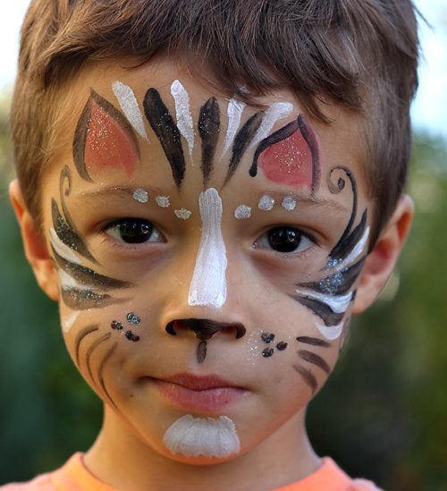 Young child's face painted with face paint to look like a cat