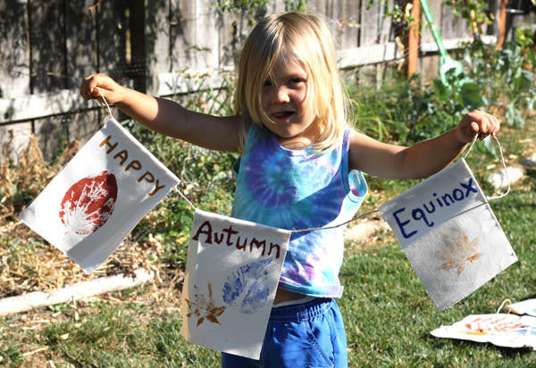 Little girl holding 3 painted hemp flags