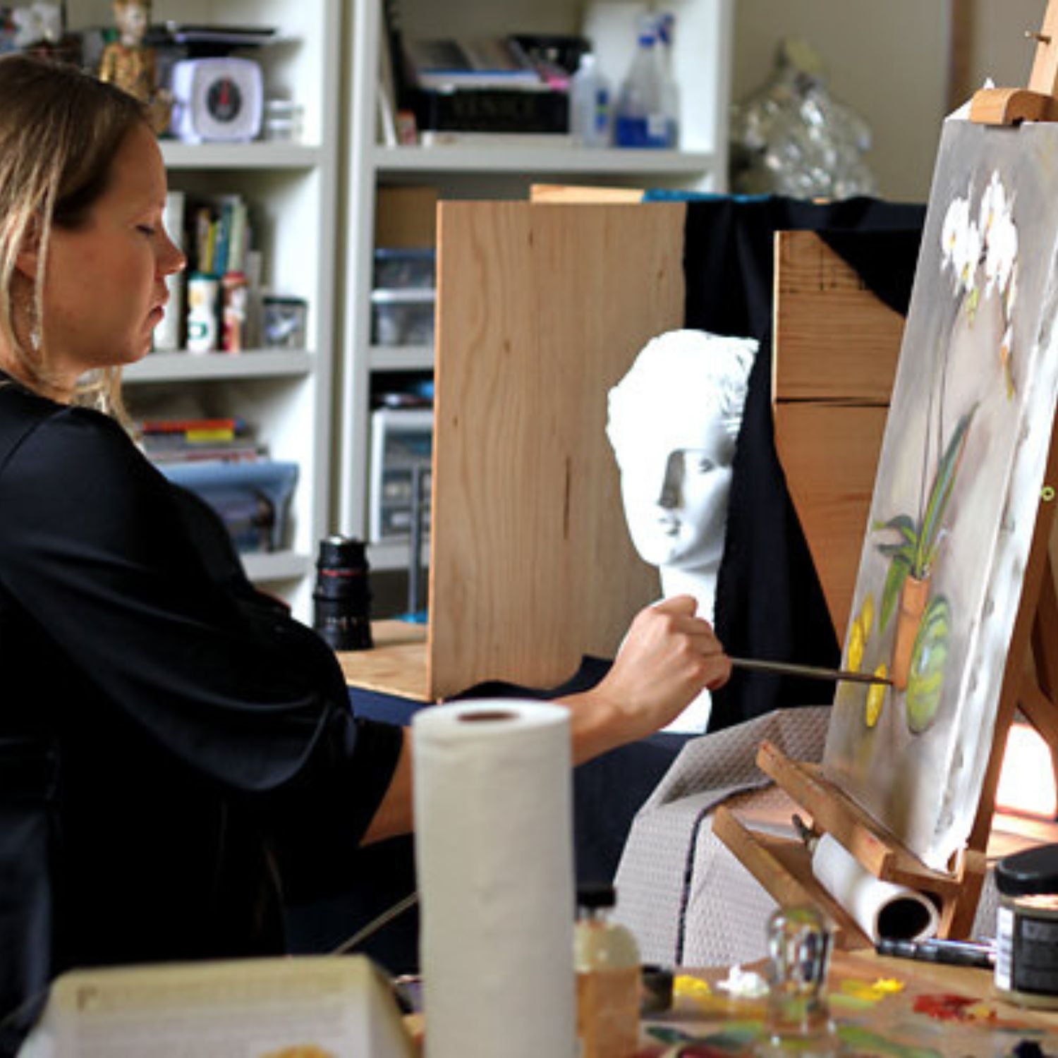 An artist in the process of painting a still life painting, using natural oil paints