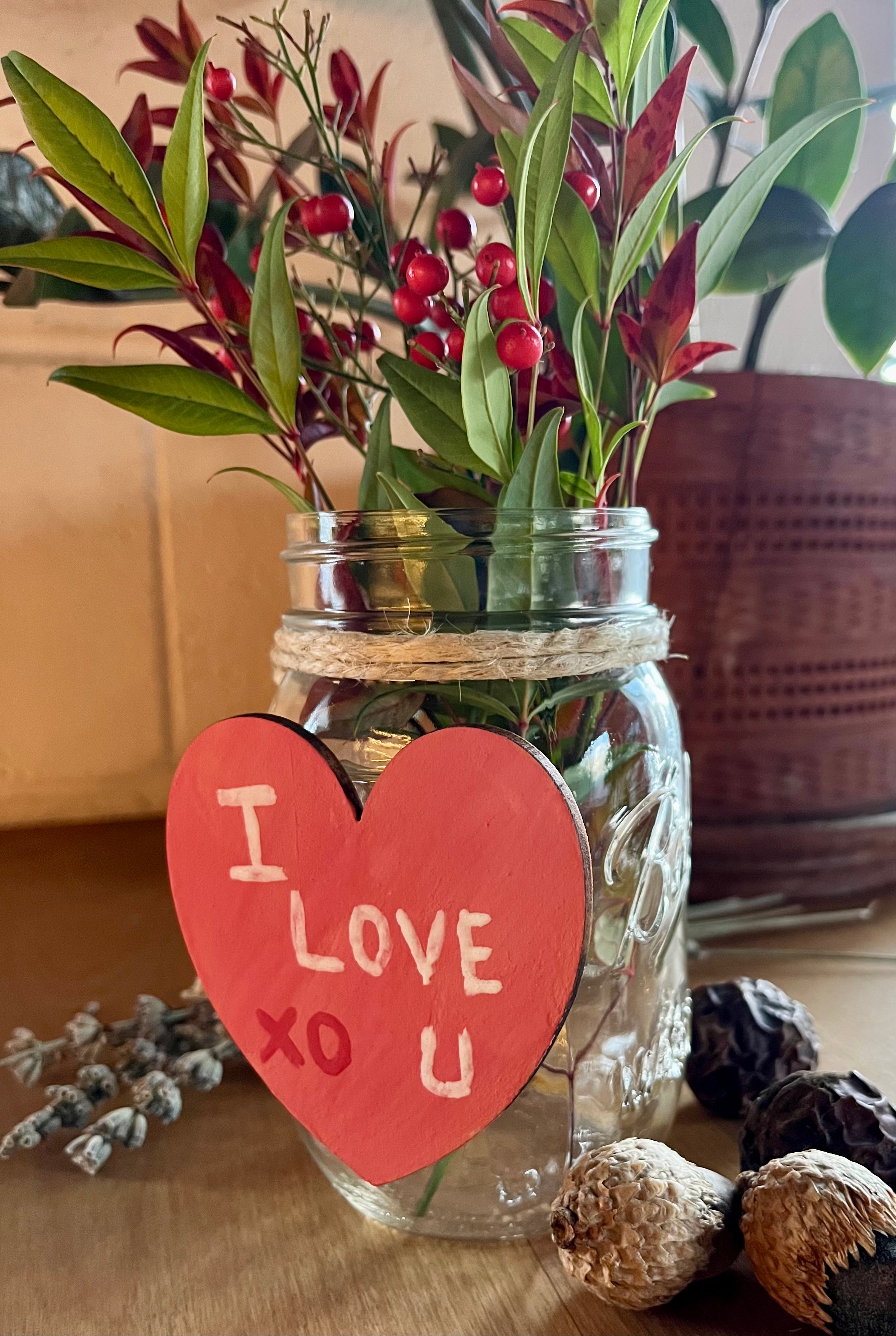 mason jar used a vase, a heart that says "I LOVE YOU XO" glued to the front