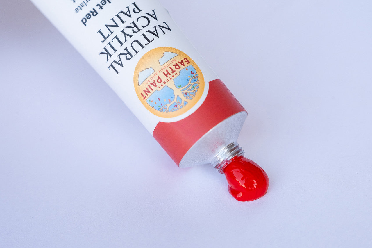 An open tube of scarlet red acrylic with paint oozing out