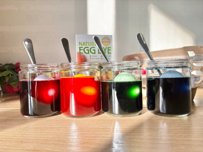 Eggs inside cups being dyed with natural egg dye