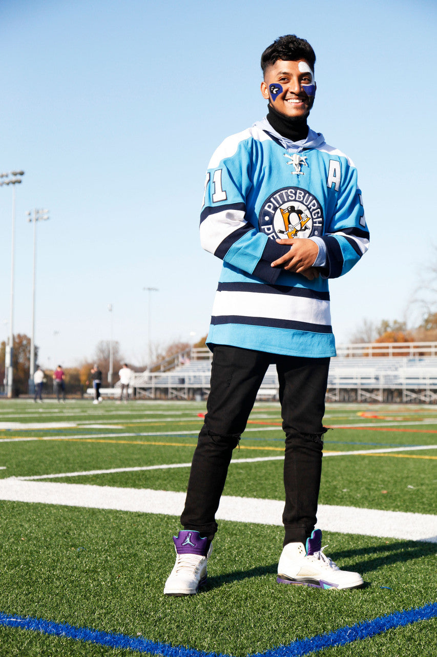 Young sports fan with face painted in team colors standing on a playing field