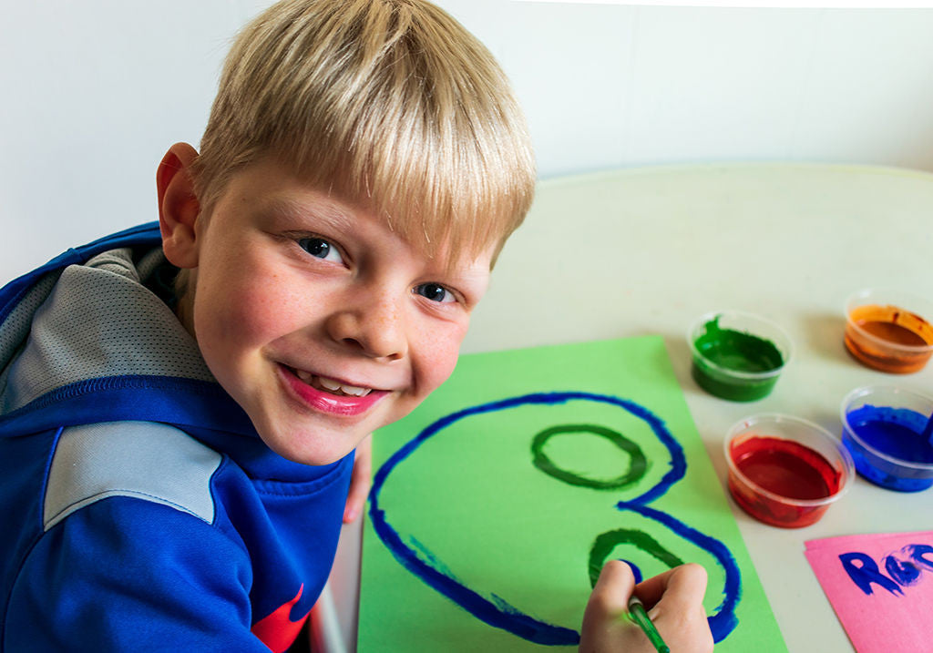 Small child painting a picture with Natural Earth Paint