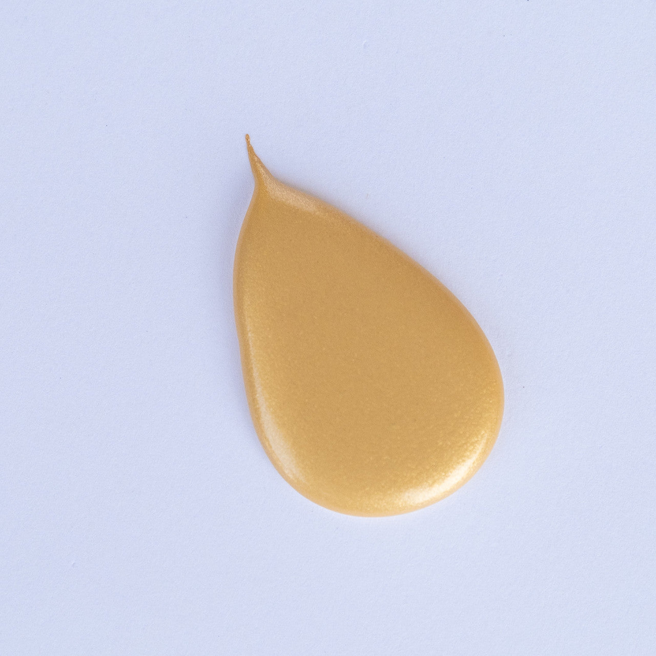 A teardrop-shaped blob of Gold Mica acrylic paint