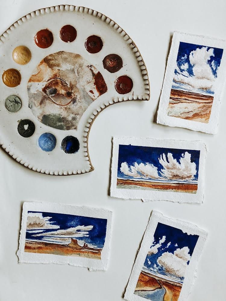 A ceramic palette and four small watercolor pictures